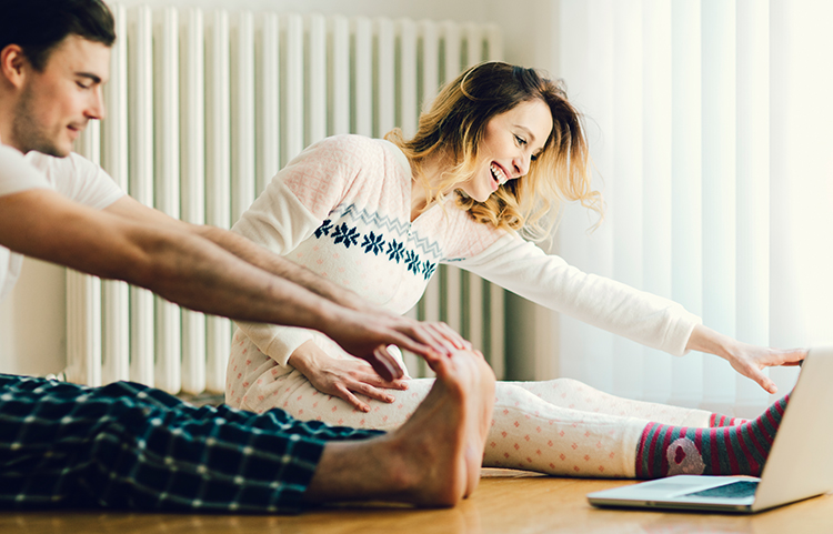 Homme et femme s'étirant en pyjama de fête